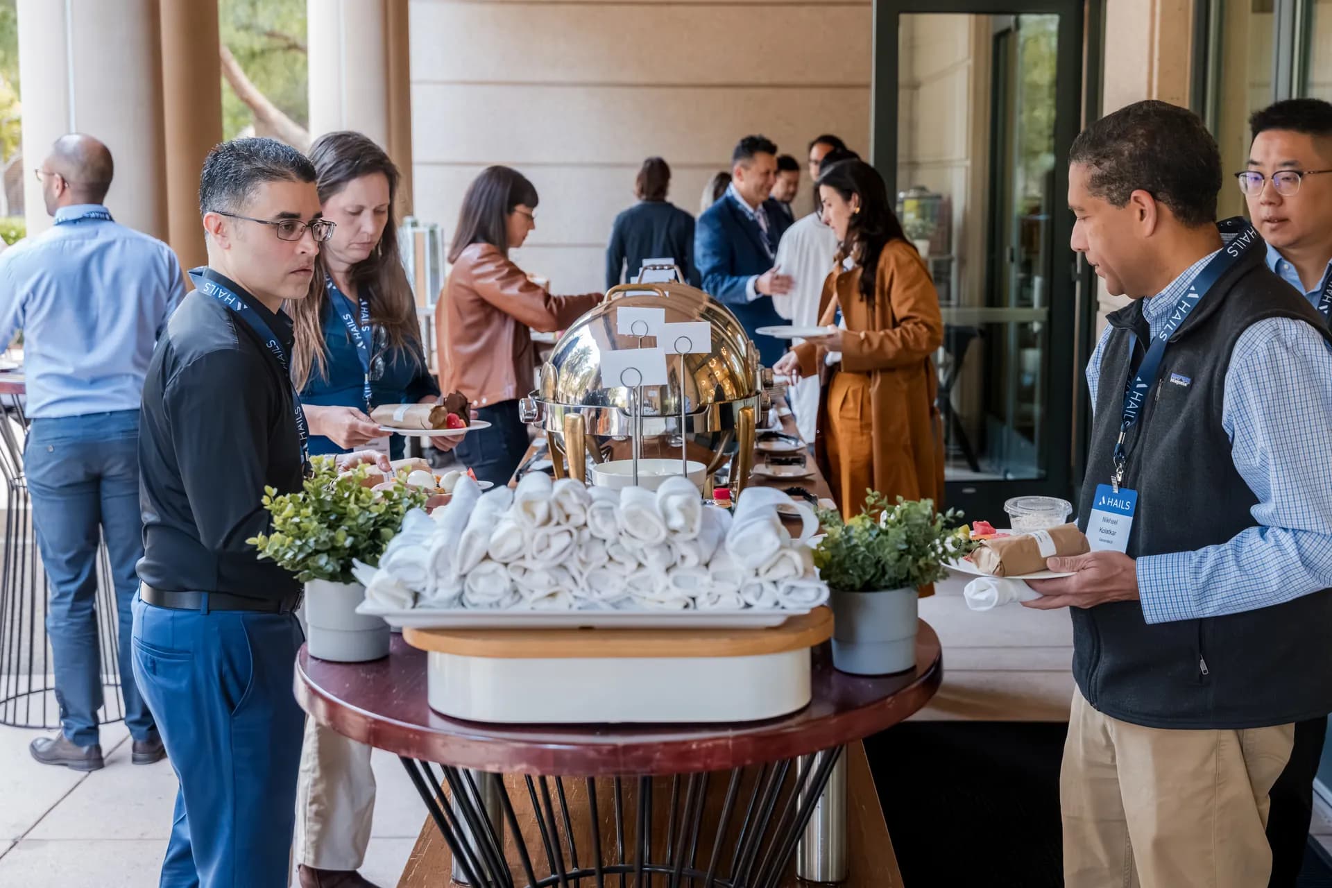 Attendees serving themselves from a buffet on an outdoor terrace