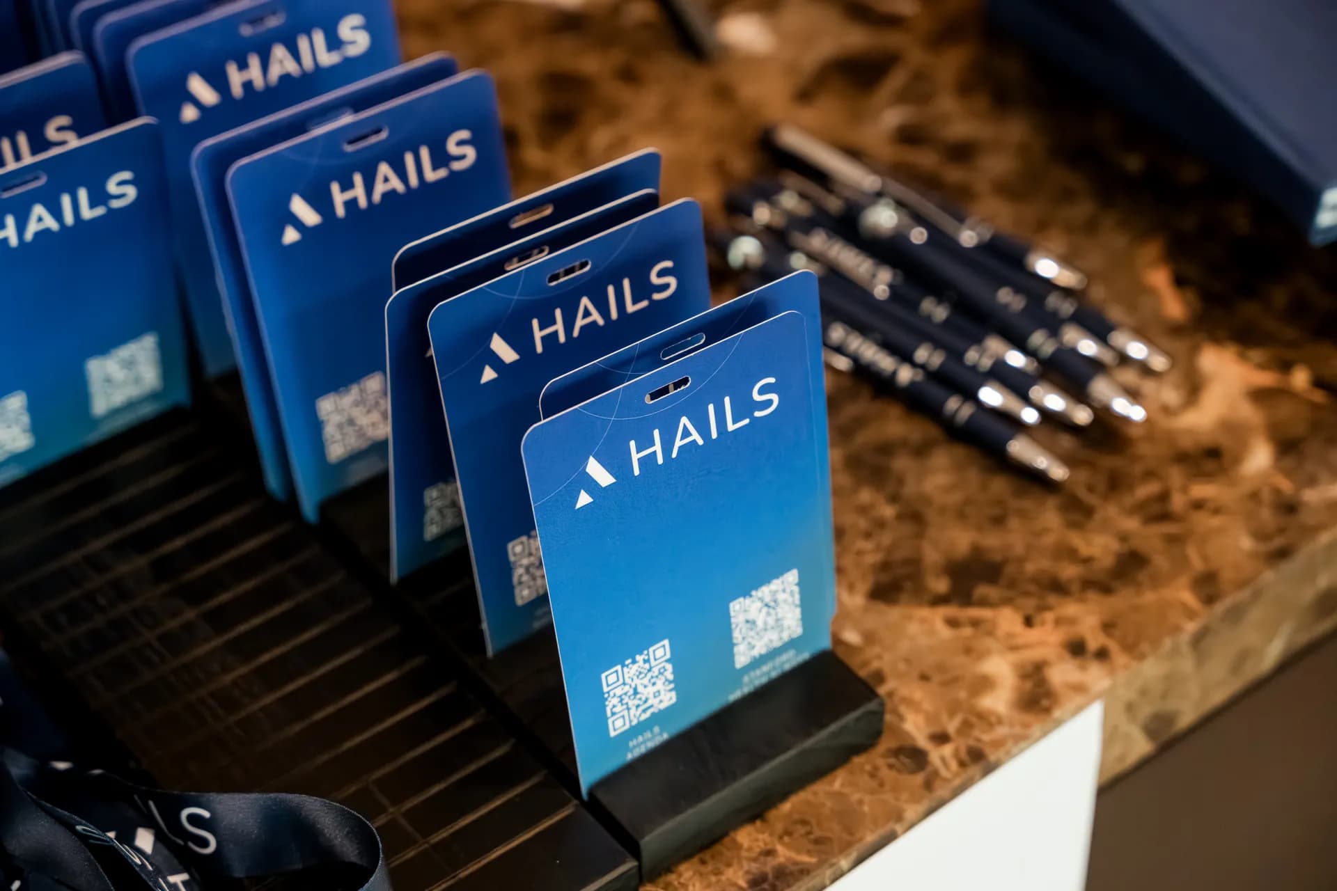 HAILS name badges and branded pens laid out on the registration counter