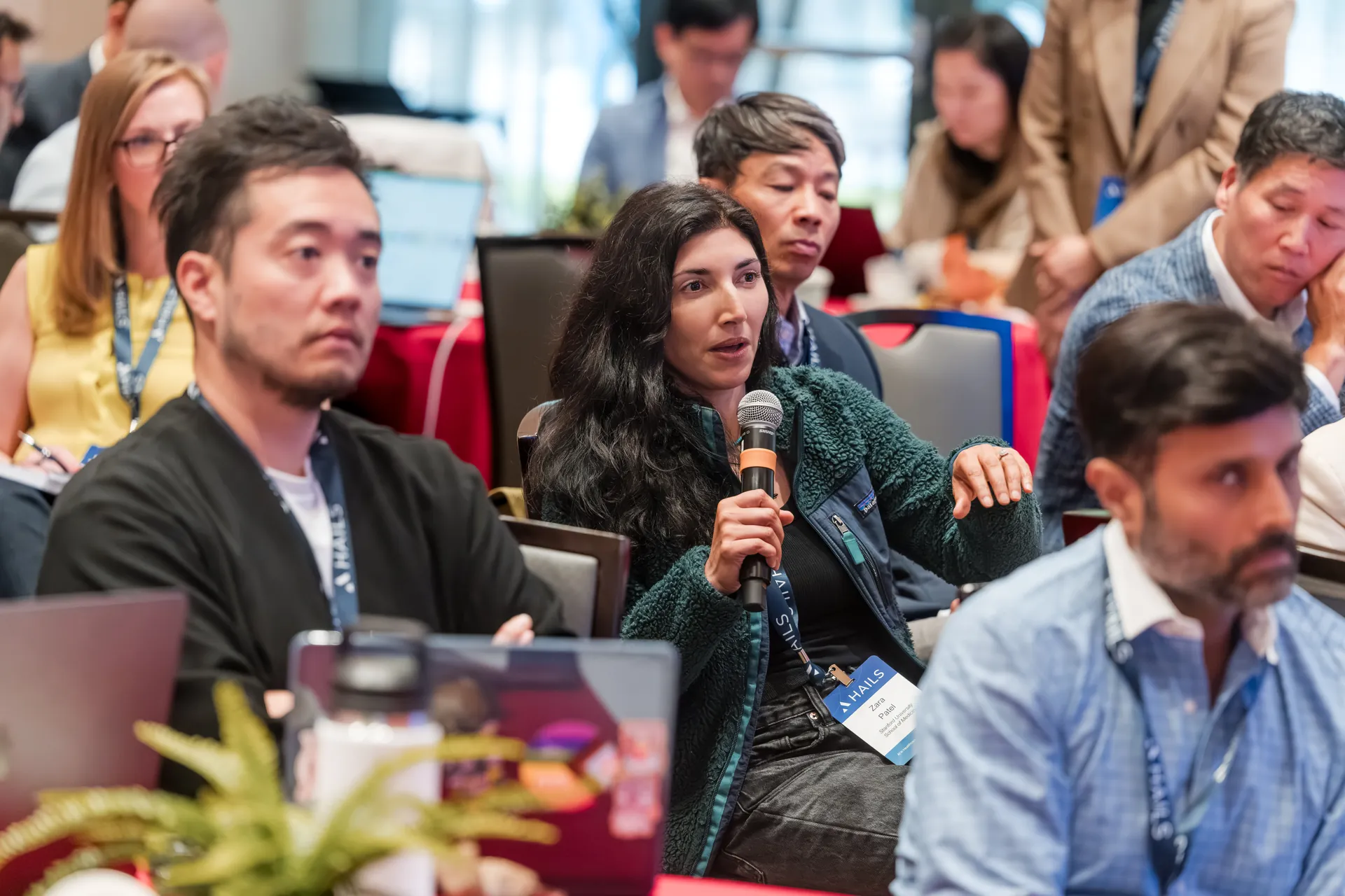 An attendee holding a microphone to ask a question from the audience