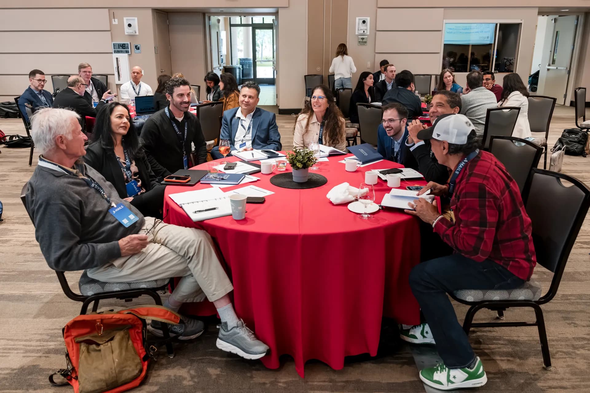 A round table of attendees laughing together between sessions